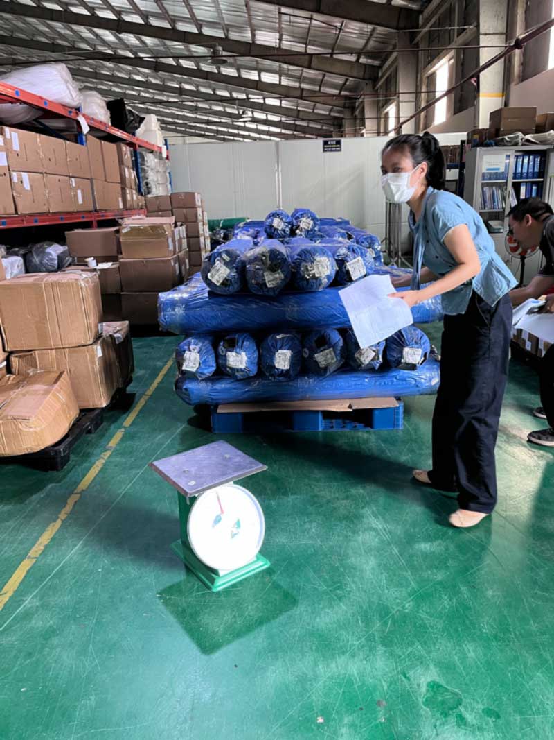 Staff checking rolls against documents beside a weighing scale